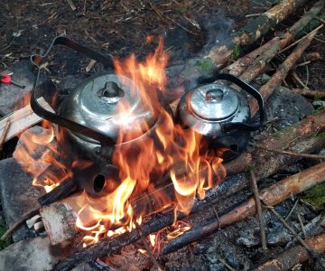 två kittlar med kokkaffe står på en rejäl eld och värms