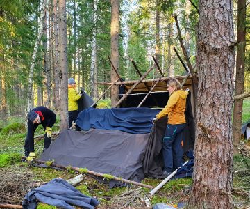 Några personer bygger på ett skydd för natten